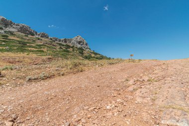 Güneşli bir günde dağa çıkan toprak ve çakıl izleri..