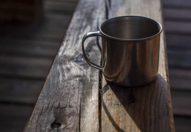 Tahta bir masada metalik bir bardak.
