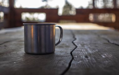 Tahta bir masada metalik bir bardak.