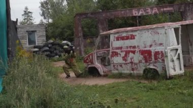 Lastiklerle çevrili bir adam paintball oynuyor.