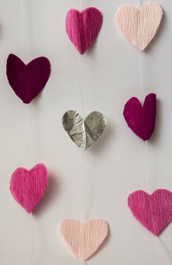 Kağıttan kesilmiş pembe kalpler.