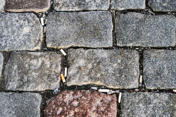 Grandes bloques de piedra y una gran cantidad de colillas de cigarrillos textura —  Fotos de Stock