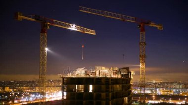 4 k binada çalışmalarına gece kış - etkin çalışma ve Vinçler, güzel arka arka plan koyu mavi gökyüzü ile çalışma hareketi yüksek katlı bir apartman sefer planı