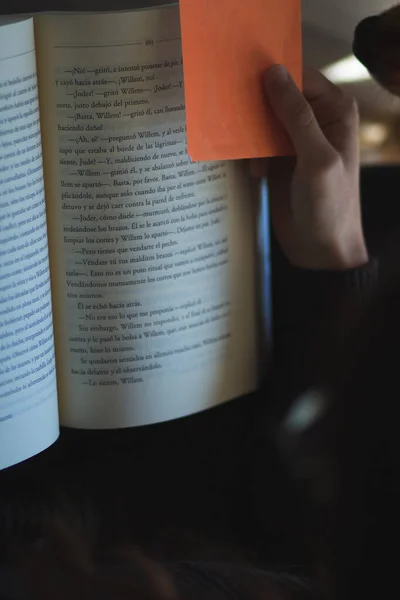 Mão Uma Mulher Segurando Separador Folhas Laranja Enquanto Livro — Fotografia de Stock