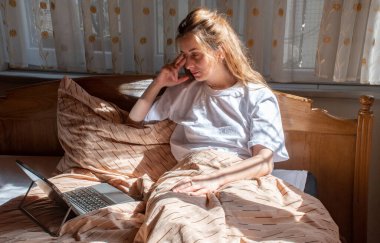 Genç bir bayan sabahın erken saatlerinde hafif güneş ışığıyla bir şey seyrediyor.