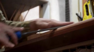 Marangoz, gitarın boynunu şekillendirmek için bir tahta dosya kullanıyor.