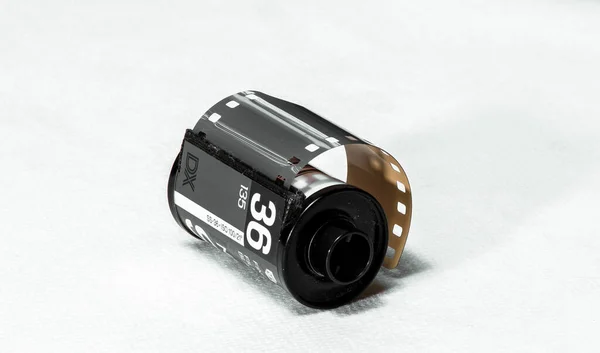 Kullanılmamış eski 35 mm 36 pozlama BW film rulosu beyaz platformda uzanıyor, yakın plan, izole edilmiş