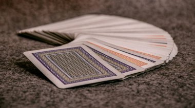 Masaya baş aşağı yerleştirilmiş eski, kullanılmış oyun kartları, mavi ve kırmızı kartlar, poker destesi.