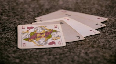 Bir oyunda masada iskambil kağıtları açıldı, bir el poker - dört el aynı ve kraliçe - yakın çekim.