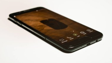 mesajlar simgesine odaklanan siyah bir akıllı telefon, beyaz arkaplanda izole edilmiş retro biçimli dokunmatik ekran, perspektif görünümü. 