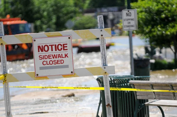 Sidewalk closed sign at flooding damage site