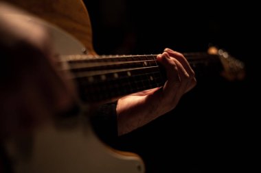 Bir adam gitar tutuyor ve çalıyor.