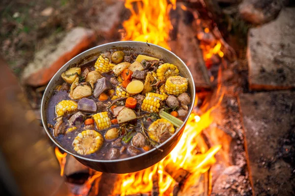 Cooking over a campfire with stewed food — Stock Photo, Image