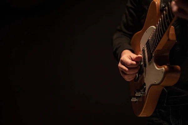 Человек, держащий в руках гитару и играющий на ней — стоковое фото