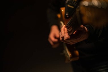 Bir adam gitar tutuyor ve çalıyor.