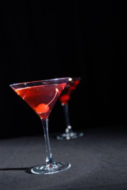 Uzun martini bardağında kırmızı vişneli kokteyl
