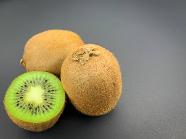 Mavi arka planda taze olgun ve yarım kivi meyvesi. Düz konum, kare biçimi