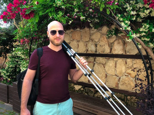 Elinde tripodu olan genç sakallı bir erkek fotoğrafçı Antalya 'nın eski kenti Kaleici' de yürüyor. Yatay stok resmi.
