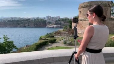 Antalya 'nın Kaleici kentindeki Hidirlik Kulesi' nde tripodla çekim yapan bir kızın tam HD videosu. Antalya 'nın eski kenti ve Akdeniz manzarası. 
