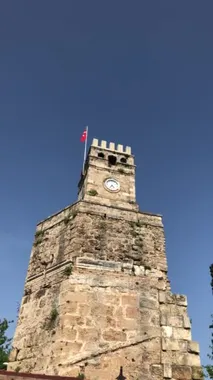 Antalya 'nın sembolü - Türkiye' nin eski Antalya Kaleici kentinde Türk bayrağı taşıyan saat kulesi. 4k dikey stok video.