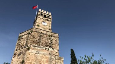 Antalya 'nın sembolü - Türkiye' nin eski Antalya Kaleici kentinde Türk bayrağı taşıyan saat kulesi. 4k stok video.