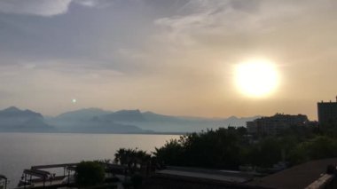 Akdeniz 'in üzerinde dağların siluetleriyle güzel bir yaz günbatımı gündoğumu. 4k stok video.
