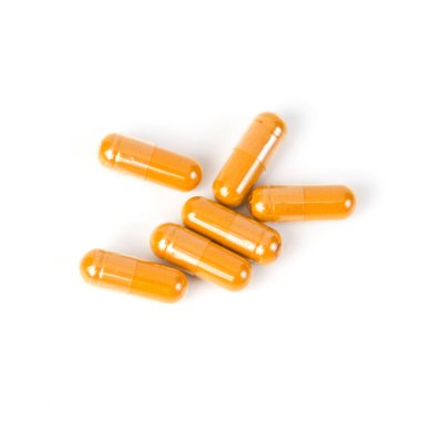 Beyaz arka plan üzerinde zerdeçal kapsül kapatın