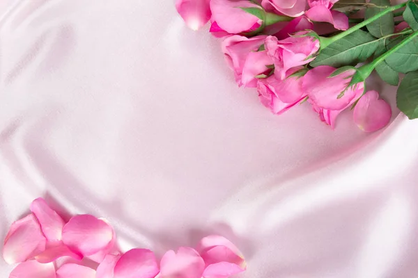 부드러운 핑크 실크 직물, 로맨스와 사랑 카드 개념에 꽃다발 달콤한 핑크 장미 꽃잎 — 스톡 사진