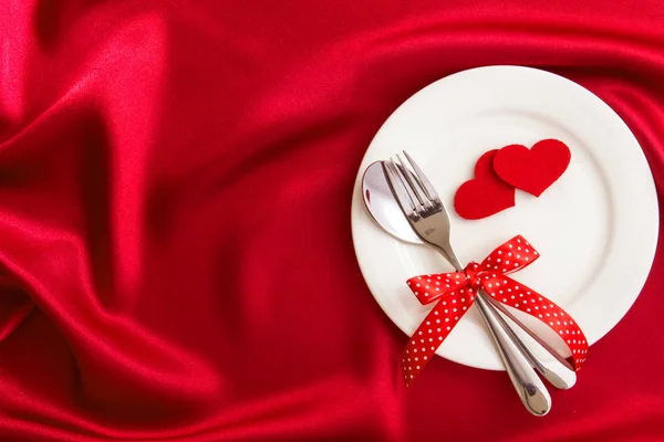 Red heart shape with White empty plate with fork and spoon on re — Stock Photo, Image