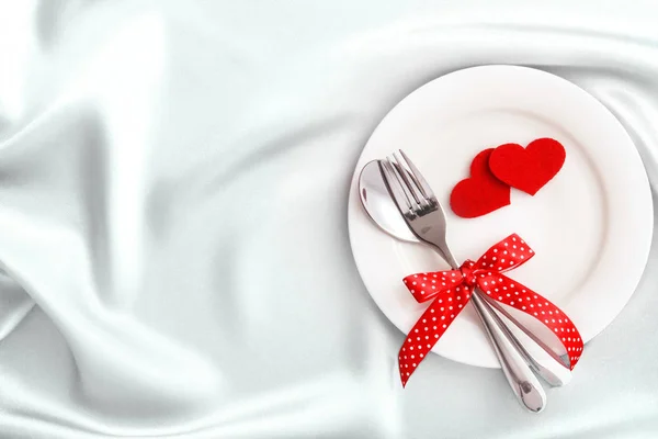 Red heart shape with White empty plate with fork and spoon on wh — Stock Photo, Image