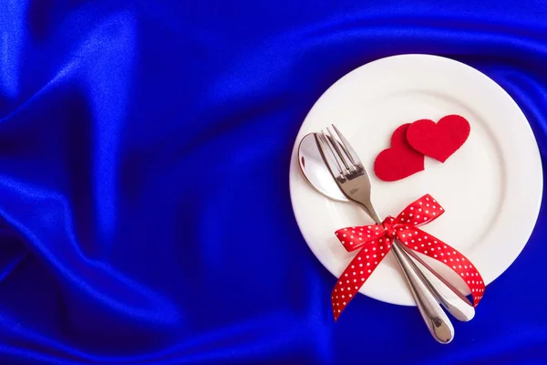 Red heart shape with White empty plate with fork and spoon on bl — Stock Photo, Image