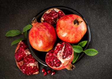 Taze kırmızı nar tohum yaprakları üzerinde siyah ile taş bac