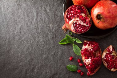 Taze kırmızı nar ve tohum yaprakları üzerinde siyah taş ile 