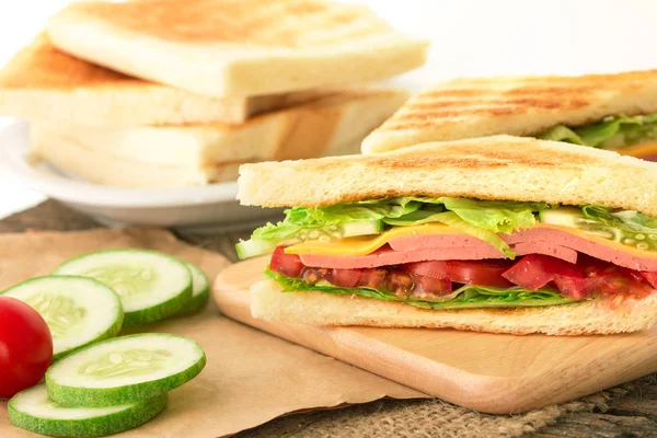 Grillezett szendvicsek kenyér, szalonna, sonka és sajt szeletelt — Stock Fotó