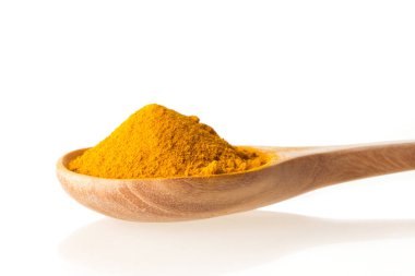 Beyaz zemin üzerine tahta kaşık kuru zerdeçal tozu kadar kapatın