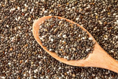 Tahta kaşık chia tohum arka plan üzerinde chia tohum kadar kapatın