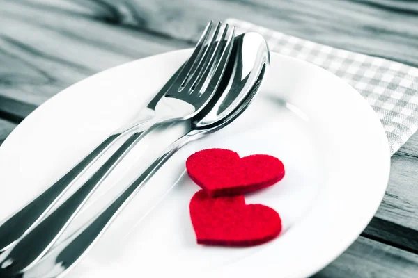 Czerwone serce kształt z biały pusty talerz z widelca i łyżki — Zdjęcie stockowe