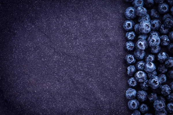 黑色的石头背景上新鲜采摘的蓝莓 — 图库照片
