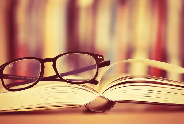 Close up opened book page and  reading eyeglasses — Stock Photo, Image