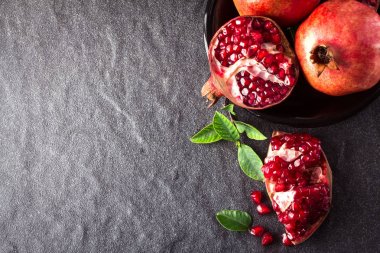 Taze kırmızı nar ve tohum yaprakları üzerinde siyah taş ile