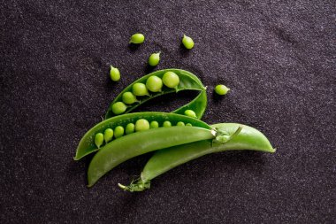 siyah taş zemin üzerine taze yeşil bezelye