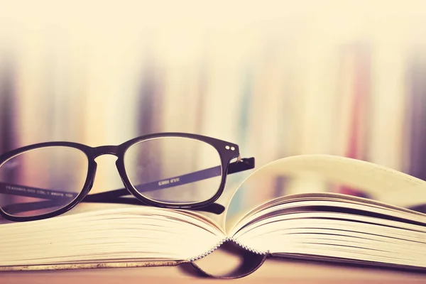 Close up opened book page and  reading eyeglasses with  blurry b — Stock Photo, Image