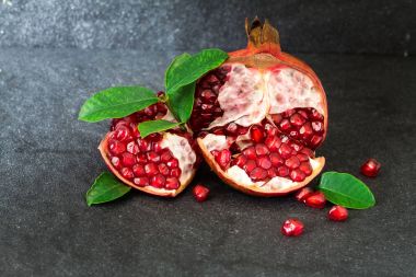 Taze kırmızı nar tohum yaprakları üzerinde siyah ile taş bac