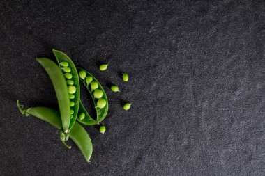 siyah taş zemin üzerine taze yeşil bezelye