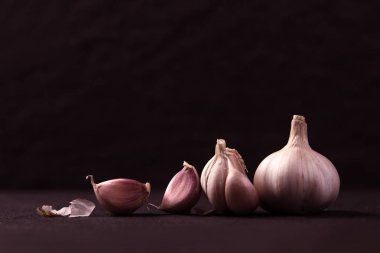  Üç bütün sarımsak ampuller bir natürmort düzenleme üzerinde gruplandırılmış