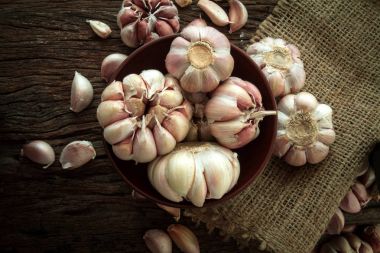 Ahşap masa üzerinde bir kapta sarımsak ampul kadar kapatın 