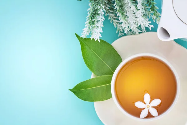 Vista superior de una taza de té caliente con hoja verde y flor en —  Fotos de Stock