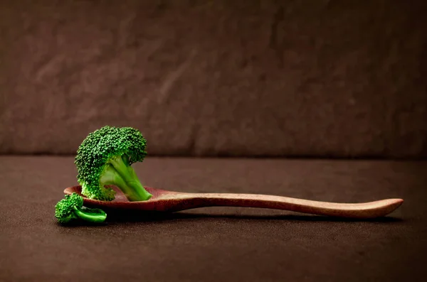 Stillleben mit frischem grünen Brokkoli auf schwarzem Steinteller — Stockfoto