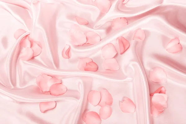 柔らかいピンク色のシルク生地、ロマンスに甘いピンクのバラの花びらと — ストック写真