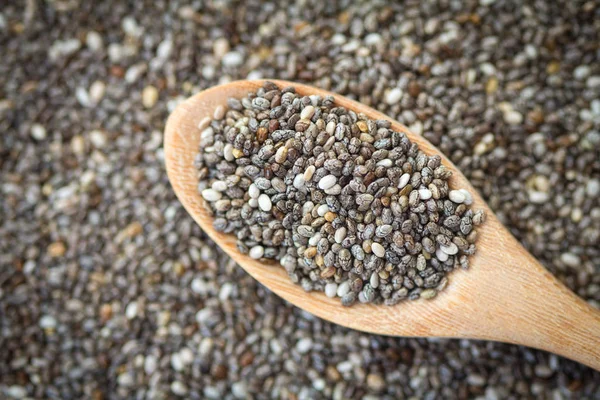 Close up sementes de chia em colher de madeira no fundo de sementes de chia — Fotografia de Stock